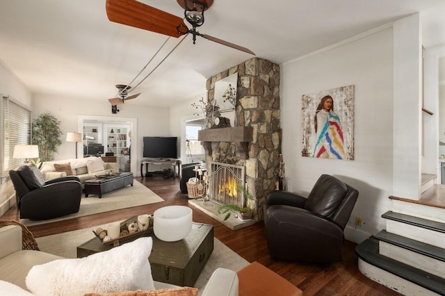 living room with dark hardwood / wood-style floors and a stone fireplace