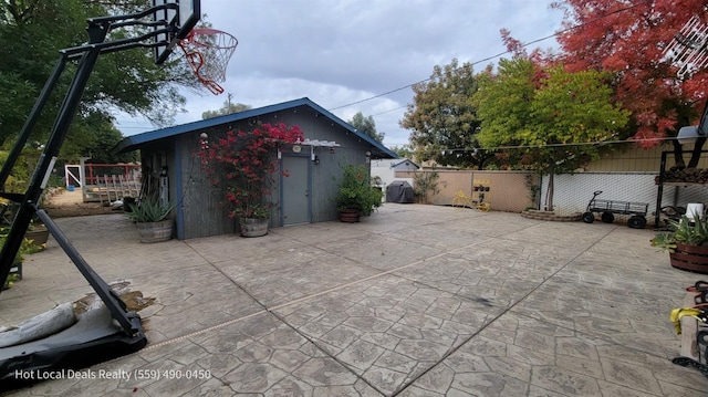 view of patio with a shed and basketball court