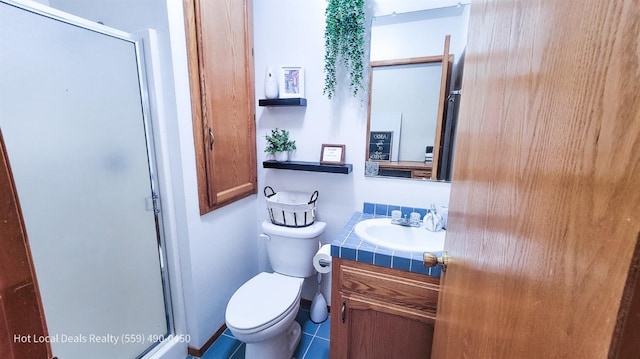 bathroom featuring vanity, toilet, and a shower with door