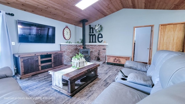 living room with lofted ceiling, light hardwood / wood-style floors, a wood stove, and wood ceiling