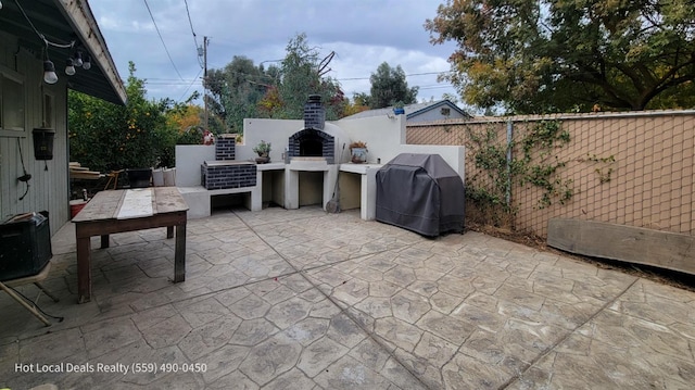 view of patio featuring grilling area and an outdoor fireplace