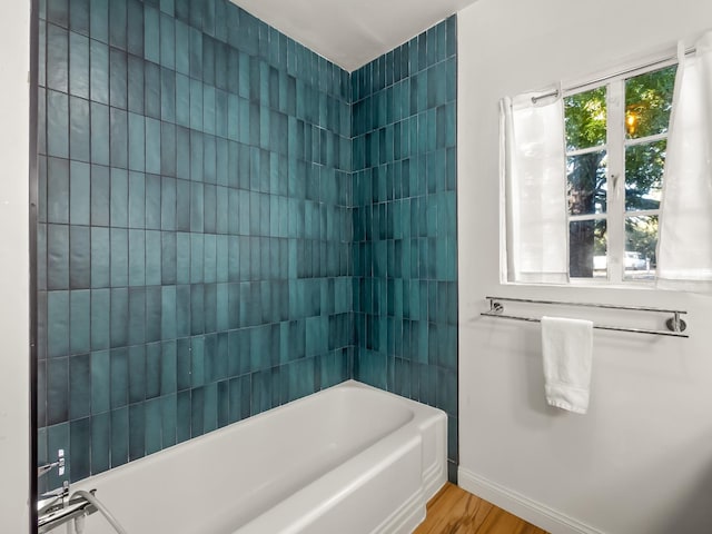 bathroom featuring wood-type flooring and tiled shower / bath combo