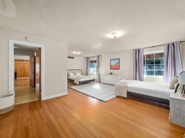 unfurnished bedroom featuring light wood-type flooring and a textured ceiling