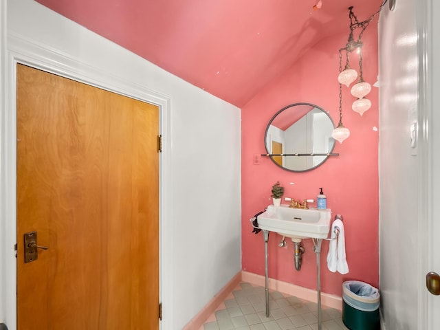 bathroom featuring tile patterned flooring, sink, and vaulted ceiling