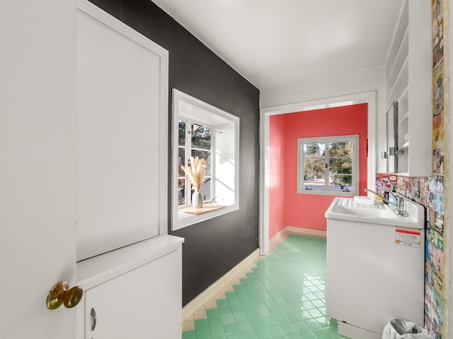 laundry area featuring sink and light tile patterned floors