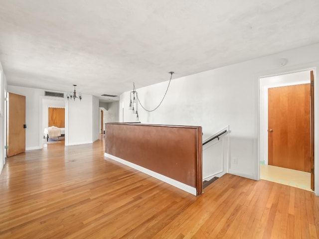 unfurnished room featuring light hardwood / wood-style flooring and an inviting chandelier