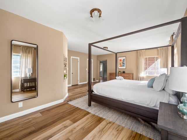 bedroom featuring multiple windows and hardwood / wood-style flooring