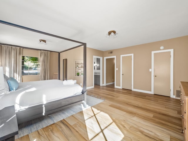 bedroom featuring hardwood / wood-style flooring and ensuite bathroom