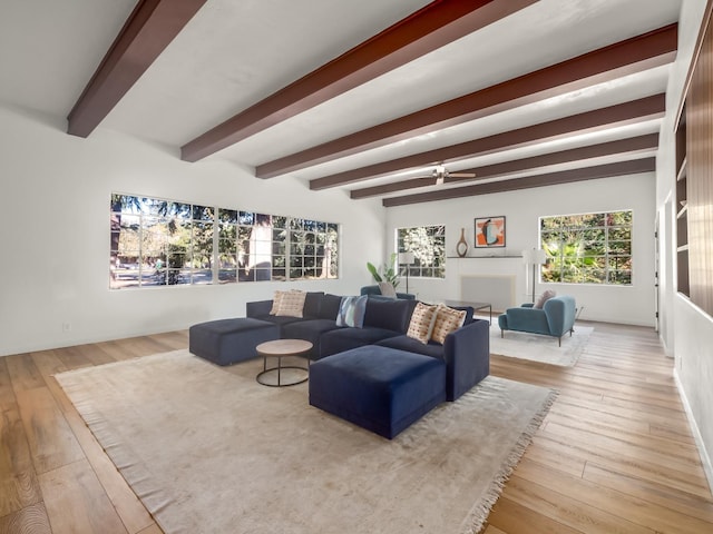 living room featuring beamed ceiling and light hardwood / wood-style flooring