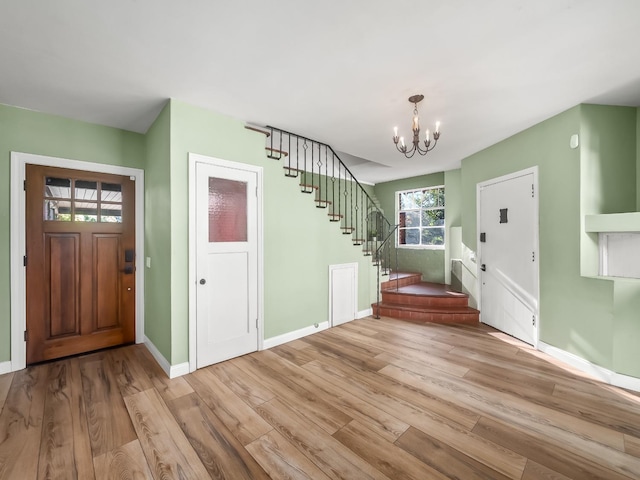 foyer entrance with a notable chandelier and light hardwood / wood-style flooring