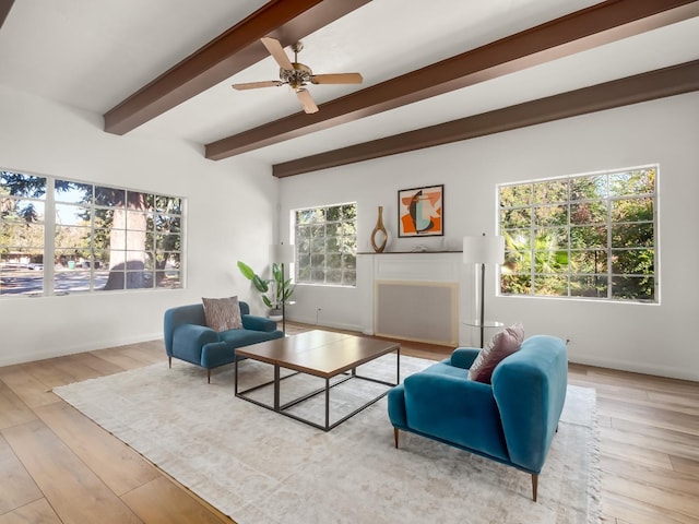 living room featuring beam ceiling, a wealth of natural light, ceiling fan, and light hardwood / wood-style floors