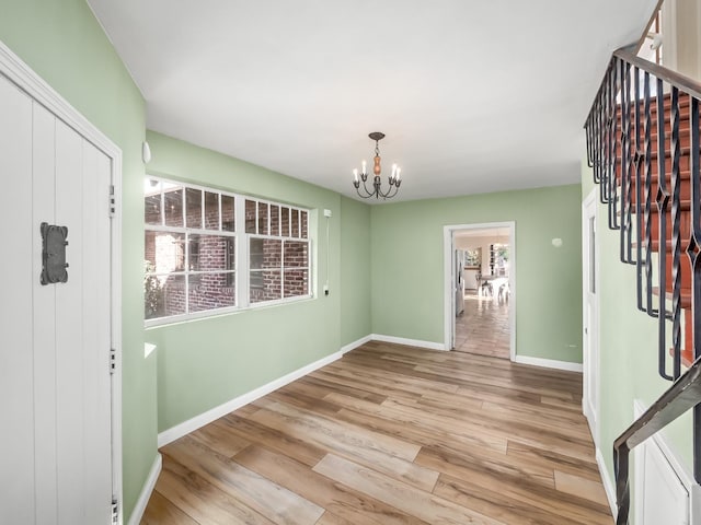 foyer entrance featuring light hardwood / wood-style floors and an inviting chandelier