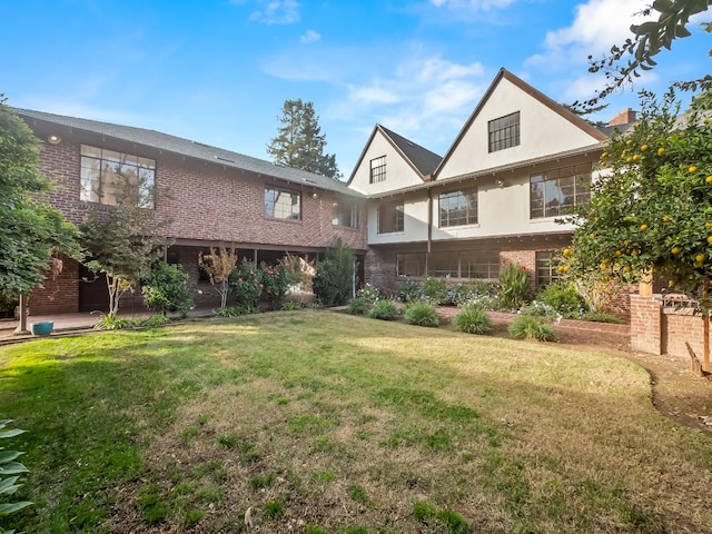 rear view of property featuring a lawn