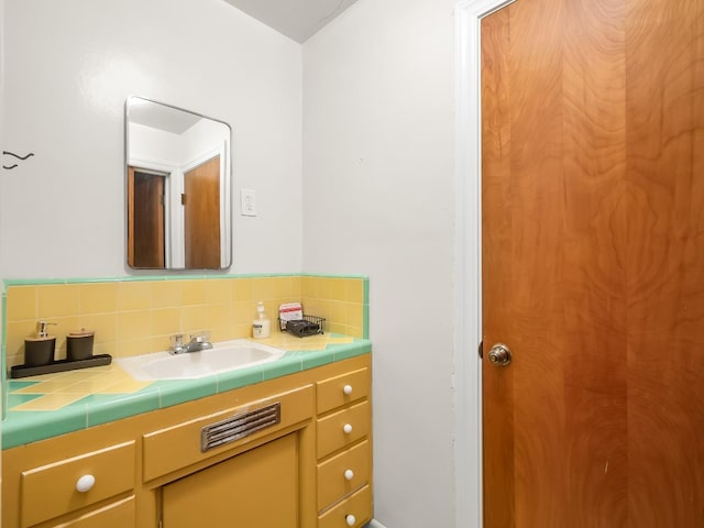 bathroom with vanity and tasteful backsplash