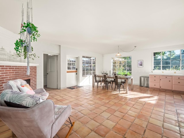 living room featuring light tile patterned floors and a brick fireplace