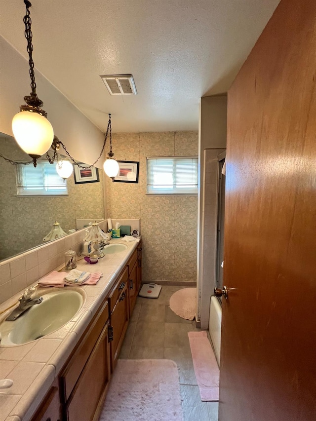 bathroom featuring tile patterned floors, vanity, a textured ceiling, and bathing tub / shower combination