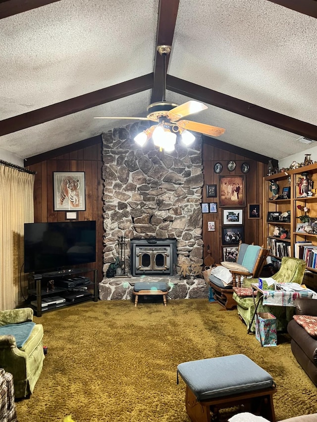 living room featuring carpet, a wood stove, a textured ceiling, and wooden walls