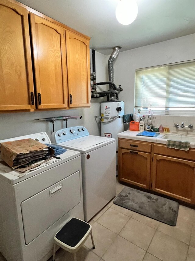 washroom with light tile patterned flooring, cabinets, separate washer and dryer, and water heater