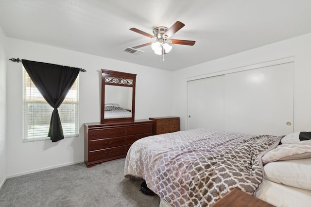 bedroom featuring a closet, light colored carpet, and ceiling fan