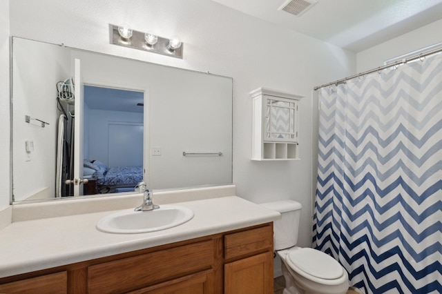 bathroom with vanity, curtained shower, and toilet