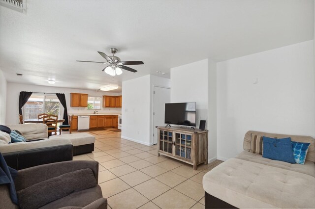 living room featuring ceiling fan, sink, and light tile patterned floors