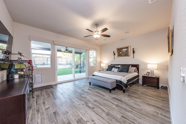 bedroom with baseboards, access to outside, and light wood-style floors