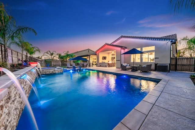 view of pool with a pool with connected hot tub, a patio area, a fenced backyard, and an outdoor living space