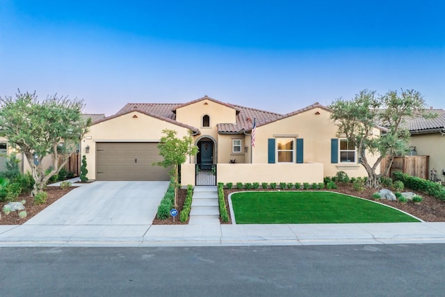 mediterranean / spanish-style house with a garage, fence, driveway, and stucco siding