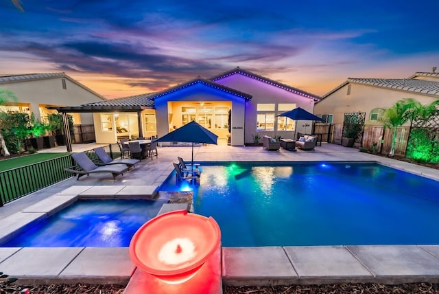 view of swimming pool featuring a patio, outdoor dining area, fence, a pool with connected hot tub, and an outdoor living space