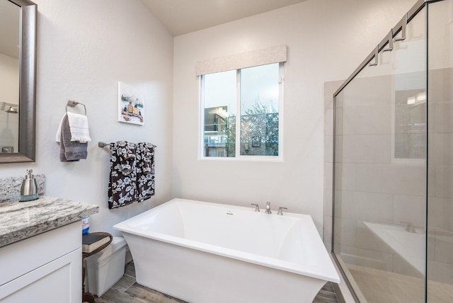 bathroom featuring a freestanding bath, wood finished floors, a shower stall, and vanity