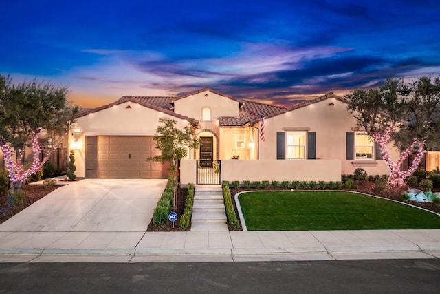 mediterranean / spanish-style house featuring driveway, a garage, fence, a front lawn, and stucco siding