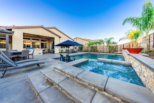 view of swimming pool with a fenced backyard, outdoor dining area, a patio, and an in ground hot tub