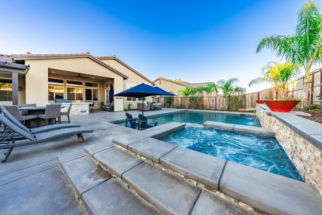 view of pool with outdoor dining space, a fenced backyard, a patio, and an in ground hot tub