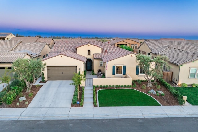 mediterranean / spanish house with a garage, fence, a tiled roof, driveway, and stucco siding