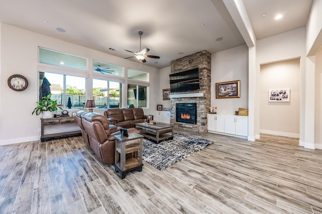 living area with light wood-style floors, baseboards, a fireplace, and visible vents