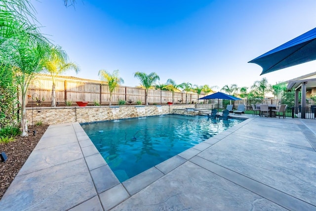 view of swimming pool with a fenced backyard, outdoor dining area, a fenced in pool, and a patio