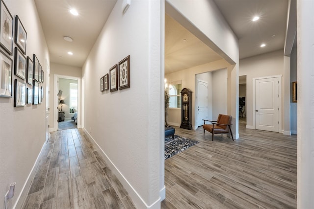 hall featuring recessed lighting, baseboards, and light wood finished floors