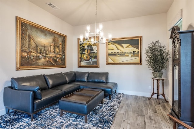 living area with an inviting chandelier, baseboards, visible vents, and wood finished floors