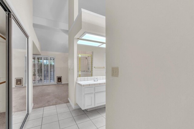 bathroom featuring vanity, tile patterned floors, and walk in shower