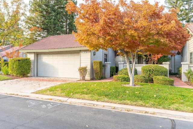 view of property hidden behind natural elements with a garage and a front lawn