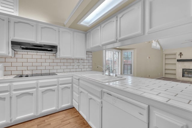 kitchen with white cabinets, sink, white dishwasher, and range hood