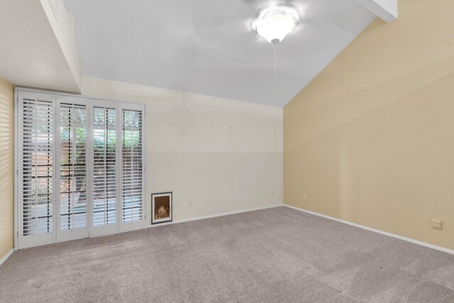 empty room with vaulted ceiling with beams and carpet floors