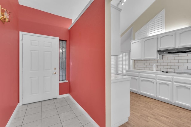 tiled foyer featuring lofted ceiling