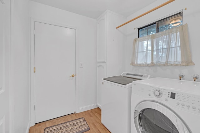 laundry room with cabinets, independent washer and dryer, and light hardwood / wood-style floors