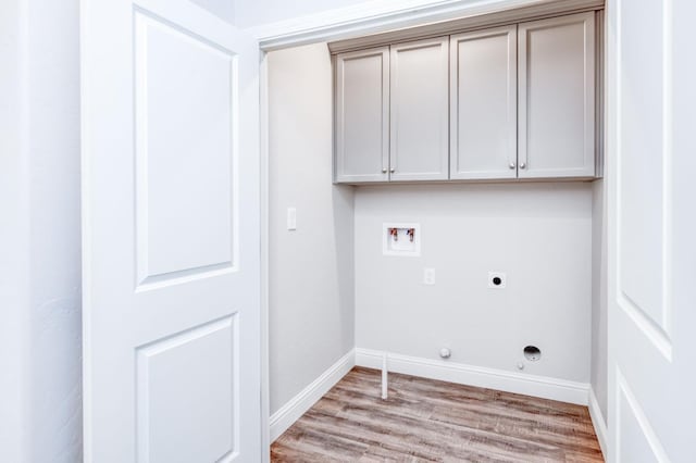 laundry room with electric dryer hookup, hookup for a washing machine, cabinets, hookup for a gas dryer, and light wood-type flooring