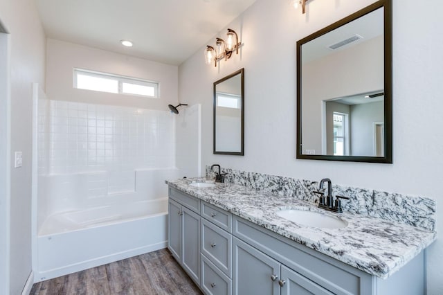 bathroom featuring shower / bathing tub combination, hardwood / wood-style floors, and vanity