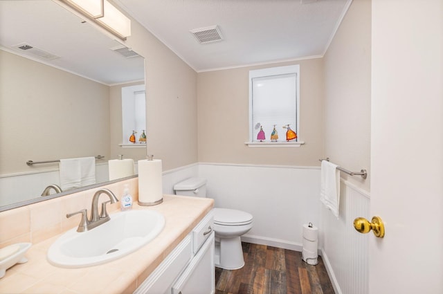 bathroom featuring vanity, hardwood / wood-style flooring, ornamental molding, and toilet