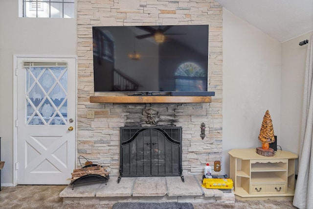 room details featuring a stone fireplace and carpet