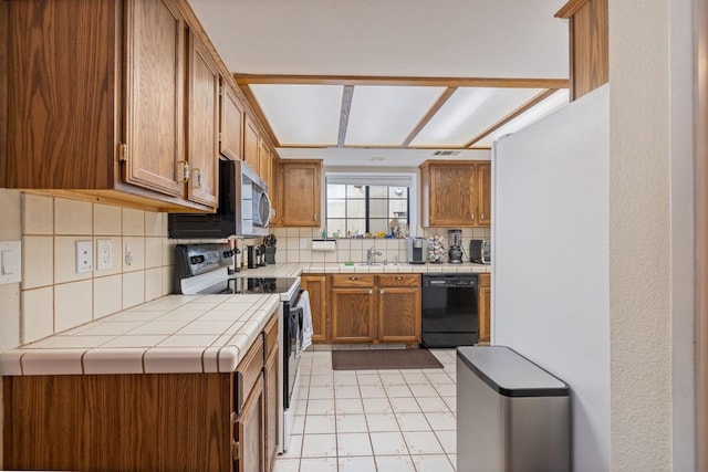 kitchen with tile countertops, white electric range, dishwasher, sink, and backsplash