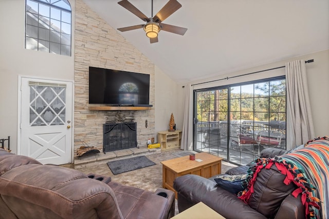 living room featuring ceiling fan, a stone fireplace, and high vaulted ceiling